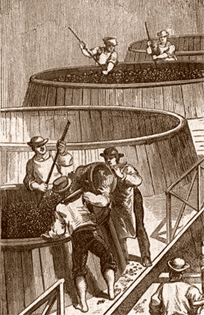 stirring grapes in huge barrels